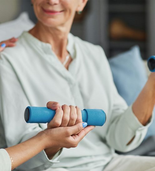Close up of smiling senior woman training with weights in retirement home, copy space